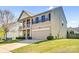 Two-story home featuring a covered porch with columns, stone accents, a two-car garage, and lush landscaping at 3010 Berry Creek Rd, Charlotte, NC 28214