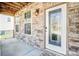 Covered front porch boasts stone accents, a decorative glass front door, and ambient lighting, enhancing curb appeal at 3010 Berry Creek Rd, Charlotte, NC 28214