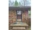 Close up of a covered front entrance to a single story brick home with pink shutters at 307 Brook St, Salisbury, NC 28146