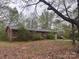 Single story brick home with covered front entrance and attached garage sits on a large wooded lot at 307 Brook St, Salisbury, NC 28146