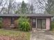 Single story brick home with covered front entrance and attached garage sits on a large wooded lot at 307 Brook St, Salisbury, NC 28146