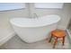 Close up of soaking tub in the bathroom with wood stool and bright tile flooring at 317 Boyd Rd, Clover, SC 29710