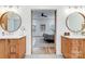 En-suite bathroom showcasing dual vanities, round mirrors, wooden cabinets and a view into the bedroom at 317 Boyd Rd, Clover, SC 29710