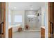 Bright bathroom with a walk-in shower, soaking tub, and tile flooring with wooden accents and fixtures at 317 Boyd Rd, Clover, SC 29710