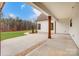 Covered patio with stained wood beams and a concrete floor looks out onto the spacious backyard at 317 Boyd Rd, Clover, SC 29710