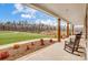 Inviting covered porch with rocking chairs overlooking a spacious lawn and pond at 317 Boyd Rd, Clover, SC 29710
