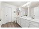 Bright bathroom featuring dual sinks, white cabinetry, ample counter space, and stylish wood-look flooring at 3414 Chagall Ct, Charlotte, NC 28205