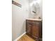 Compact bathroom featuring a wooden vanity, modern fixtures, a round mirror, and neutral decor at 3414 Chagall Ct, Charlotte, NC 28205