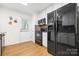 Efficient kitchen featuring dark appliances, light cabinetry, a modern tile backsplash, and a convenient exterior door at 3414 Chagall Ct, Charlotte, NC 28205