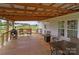 Spacious covered back porch with outdoor seating, grill, and a view of the expansive backyard at 34958 Lowder Rd, New London, NC 28127