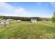 Expansive backyard with detached garage and scenic wooded backdrop at 34958 Lowder Rd, New London, NC 28127