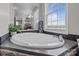 Bright bathroom features a soaking tub with brick surround and a large window, creating a relaxing ambiance at 34958 Lowder Rd, New London, NC 28127