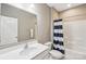 Bright bathroom featuring a white vanity, large mirror, and tub with a blue striped shower curtain at 4004 Henshaw Rd # 448, Waxhaw, NC 28173