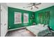 Stylish bedroom with green walls, two windows, wood floors, and a unique decorative wall feature at 4004 Henshaw Rd # 448, Waxhaw, NC 28173