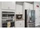 Modern kitchen with stainless steel appliances, double oven, and sleek white cabinetry at 4004 Henshaw Rd # 448, Waxhaw, NC 28173