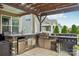 Well-equipped outdoor kitchen with a built-in grill, stainless steel appliances, and stone accents at 4004 Henshaw Rd # 448, Waxhaw, NC 28173