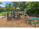 Inviting playground with slides, climbing structures, and a picnic table, perfect for Gathering fun in a natural setting at 4004 Henshaw Rd # 448, Waxhaw, NC 28173
