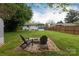 Charming backyard featuring a firepit, shed, lush greenery, and a well-maintained lawn at 4244 Donnybrook Pl, Charlotte, NC 28205