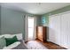 Cozy bedroom with hardwood floors, complemented by a charming dresser and natural light from the window at 4244 Donnybrook Pl, Charlotte, NC 28205