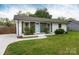 Charming single-story home with green and white painted brick and siding, and a well-manicured lawn at 4244 Donnybrook Pl, Charlotte, NC 28205