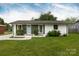 Inviting home with green and white siding, featuring manicured landscaping and a well-maintained lawn at 4244 Donnybrook Pl, Charlotte, NC 28205