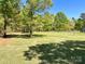 Expansive backyard featuring lush green grass and mature trees, offering plenty of room for outdoor activities at 4285 Palmer Lloyd Rd, Lancaster, SC 29720