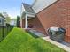 Brick home exterior with small yard, covered porch and grill at 4303 Patriots Hill Rd, Mint Hill, NC 28227