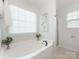 Spa-like soaking tub in a bright bathroom featuring patterned floors and natural light at 4303 Patriots Hill Rd, Mint Hill, NC 28227