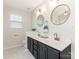 Bathroom with dual sinks, black cabinets, granite countertops and modern fixtures at 4303 Patriots Hill Rd, Mint Hill, NC 28227