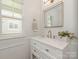 Clean and updated bathroom vanity with marble countertops, gold hardware and framed mirror at 4303 Patriots Hill Rd, Mint Hill, NC 28227