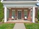 Inviting front porch with brick facade and seating, perfect for enjoying the outdoors at 4303 Patriots Hill Rd, Mint Hill, NC 28227