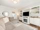 Well-lit living room with a fireplace, TV, built-in shelving and a comfortable sectional sofa at 4303 Patriots Hill Rd, Mint Hill, NC 28227