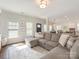 Cozy living space featuring a large sectional sofa, hardwood floors, and ample natural light at 4303 Patriots Hill Rd, Mint Hill, NC 28227