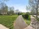 Community walking path through grassy common area at 4303 Patriots Hill Rd, Mint Hill, NC 28227