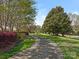 Paved walking path amongst trees and benches in a common area at 4303 Patriots Hill Rd, Mint Hill, NC 28227