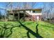 Backyard with a raised deck, wooden staircase, brick foundation, and lush green grass at 5451 Gunpowder Dr, Hickory, NC 28601