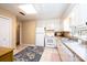 Traditional kitchen with white cabinets, appliances and tile flooring for easy maintenance and bright light from the window at 5451 Gunpowder Dr, Hickory, NC 28601