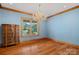 Bright bedroom with blue walls, hardwood floors, and a large window at 5546/5510 Hoodtown Rd, Sharon, SC 29742