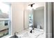 Bright bathroom with quartz countertop, black faucet, and large mirror with modern lighting at 615 Billingsley Rd, Charlotte, NC 28211