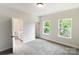 Bright bedroom featuring carpet, two windows with green leafy view, and an en suite bathroom at 615 Billingsley Rd, Charlotte, NC 28211