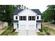 Wide view of a modern home with black roof, white siding, and two-car garages at 615 Billingsley Rd, Charlotte, NC 28211