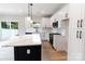 Open kitchen with white cabinets, stainless appliances, island, and sliding door to backyard at 615 Billingsley Rd, Charlotte, NC 28211