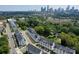 Aerial view of modern townhomes with city skyline in the background, surrounded by trees at 648 W End Dr, Charlotte, NC 28208