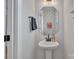 Stylish half-bathroom with a pedestal sink, octagon mirror, and unique decorative touches at 648 W End Dr, Charlotte, NC 28208
