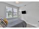 Cozy bedroom features a large window providing natural light, a television, and plush carpet at 648 W End Dr, Charlotte, NC 28208