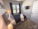 Well-lit bedroom featuring a queen bed, bedside table with a lamp, and large window at 648 W End Dr, Charlotte, NC 28208