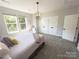 Bright bedroom with neutral tones, pendant lighting, plush carpet, and ample closet space at 648 W End Dr, Charlotte, NC 28208