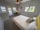 Sunlit bedroom boasting a ceiling fan, carpet, desk, and access to a private balcony at 648 W End Dr, Charlotte, NC 28208