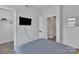 Bright bedroom with a closet, adjacent to a television set, and an open door to a hallway at 648 W End Dr, Charlotte, NC 28208