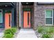 Close-up of a modern brick townhome's vibrant orange front door with sidelight window and landscaping at 648 W End Dr, Charlotte, NC 28208